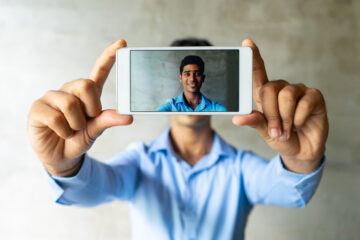 Retrato del hombre de negocios sonriente que toma el selfie con smartphone.